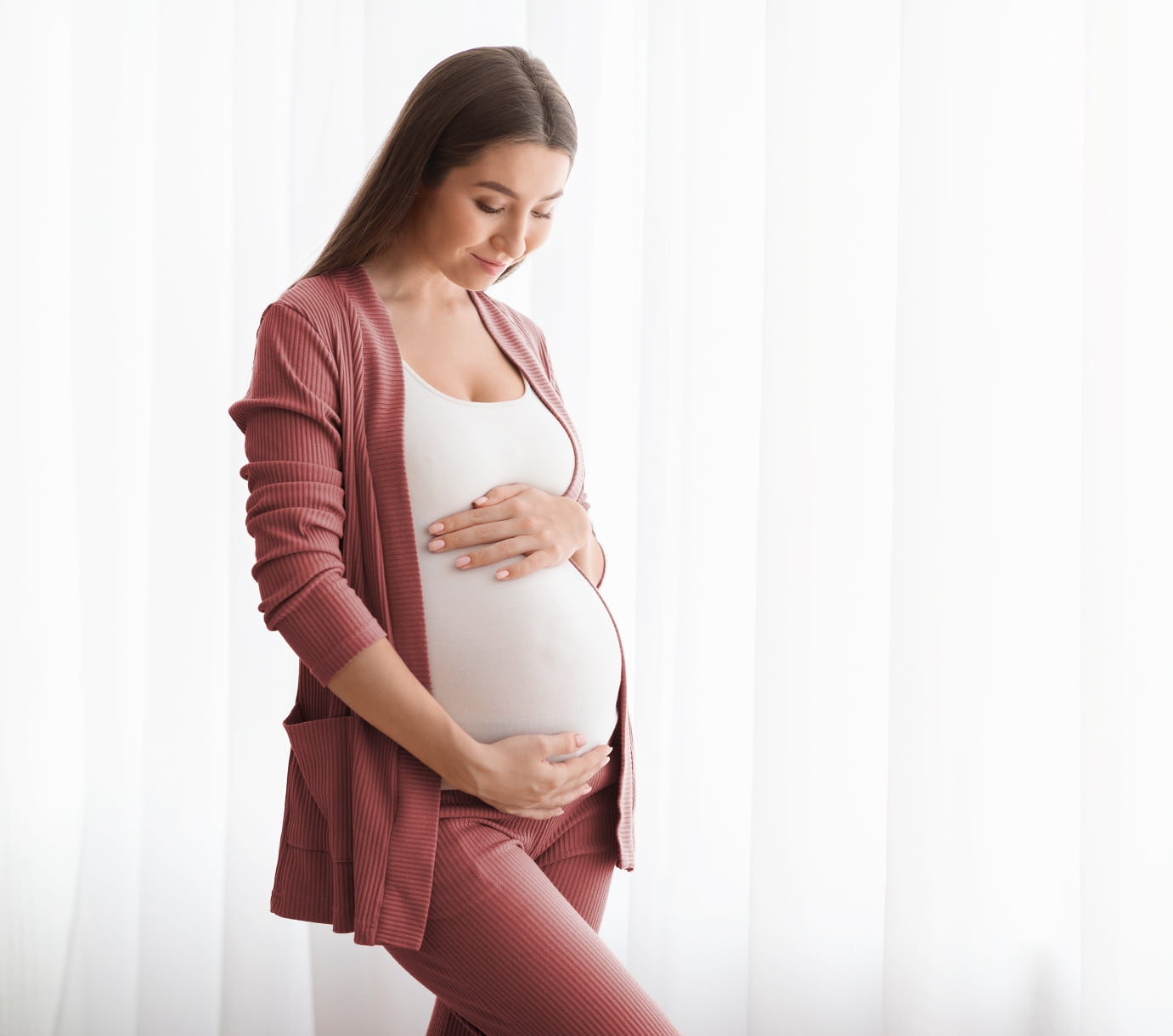Young pregnant woman admiring her belly