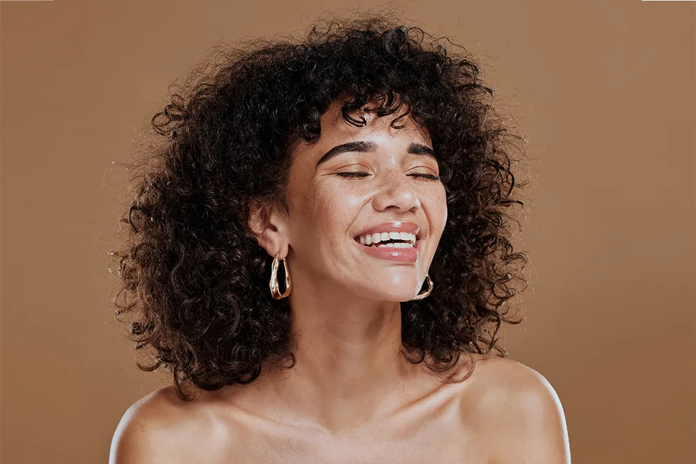 Happy woman with afro hair and beautiful skin