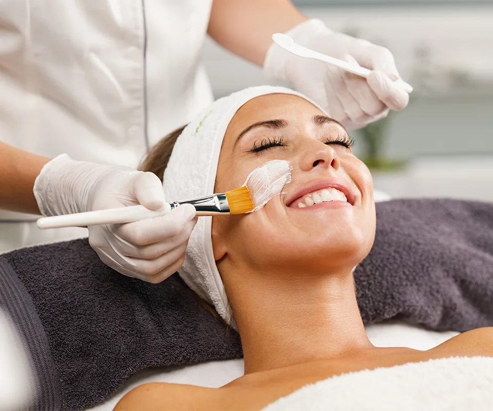Smiling woman receiving facial treatment