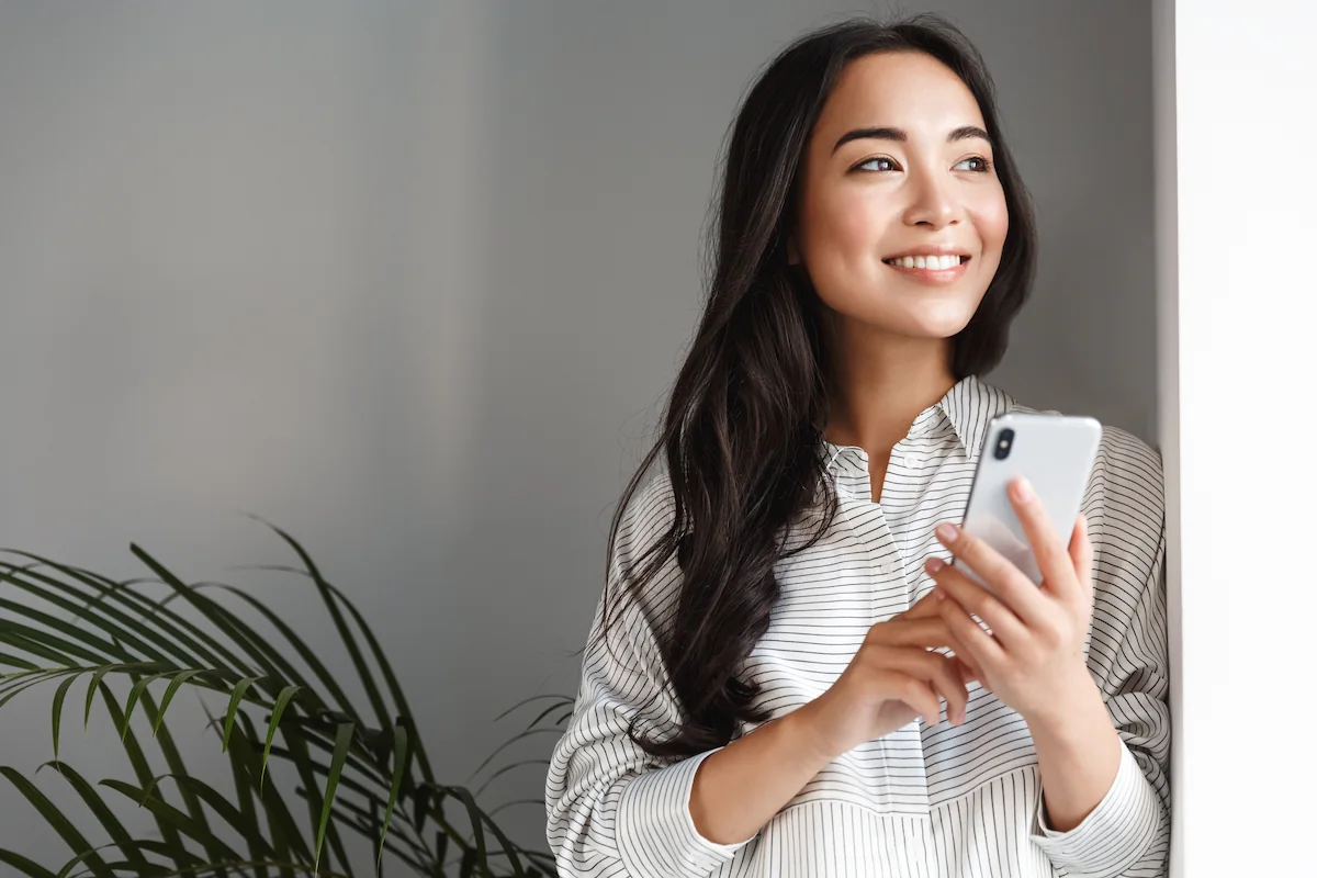 Happy beautiful woman holding phone
