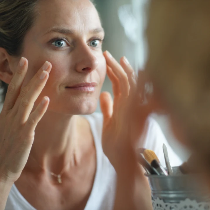 woman looking in the mirror at her botox results