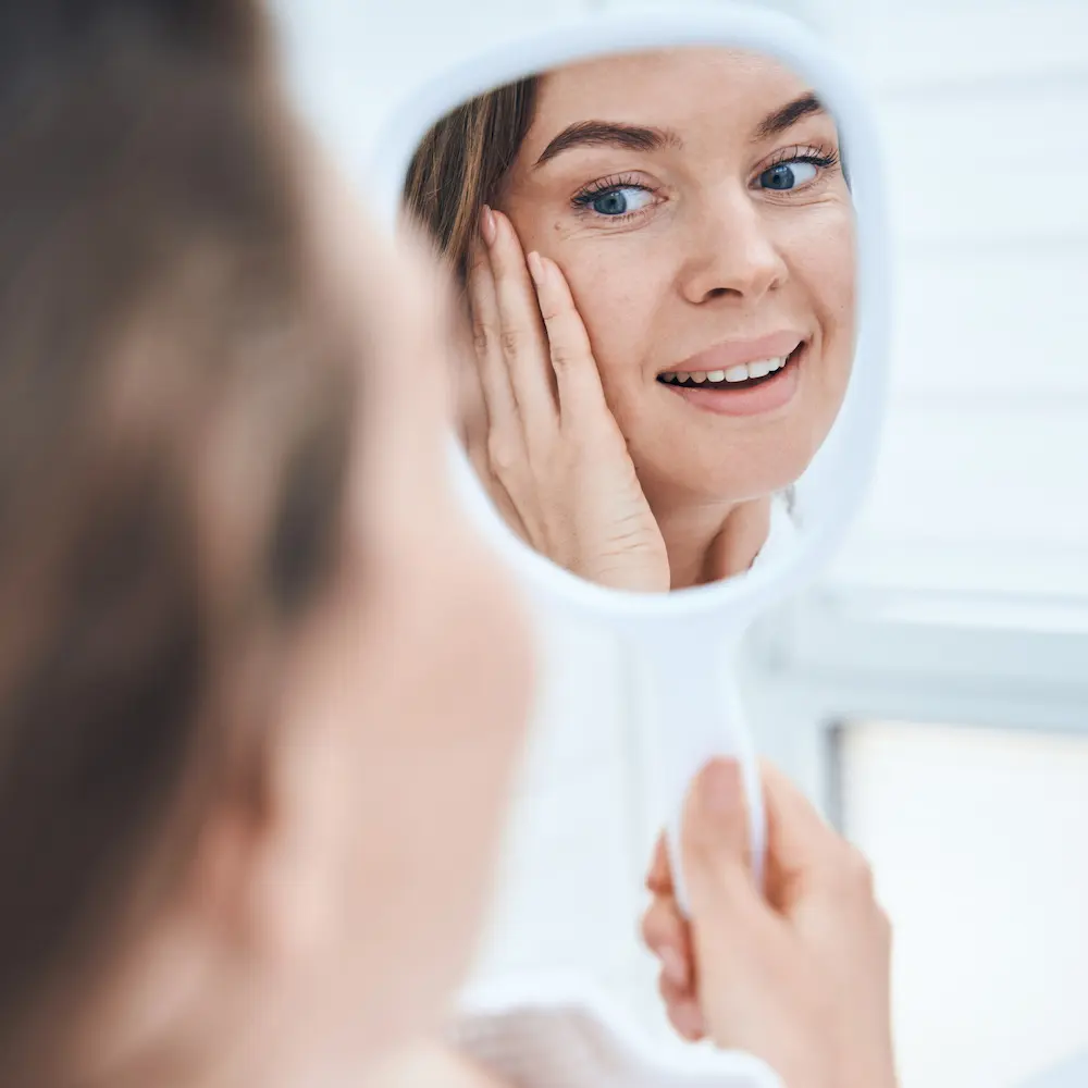 patient looking in mirror at her filler results