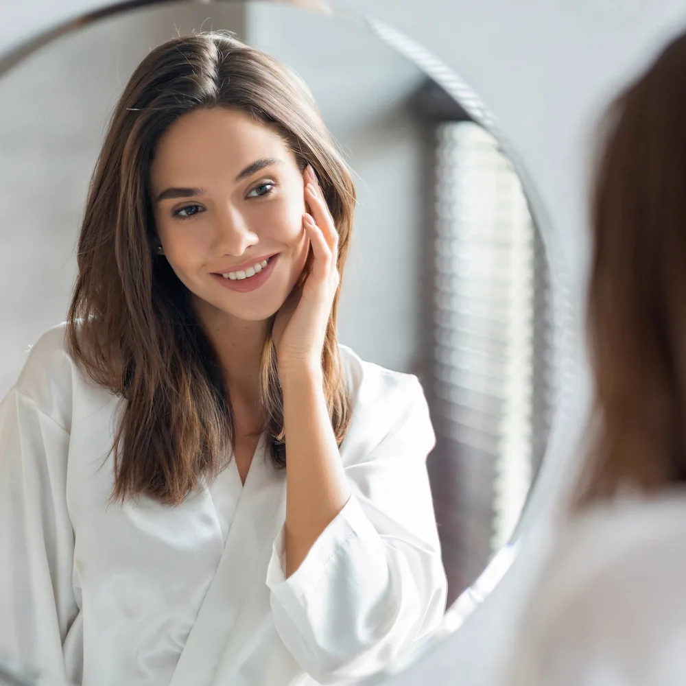 woman looking in the mirror at her results