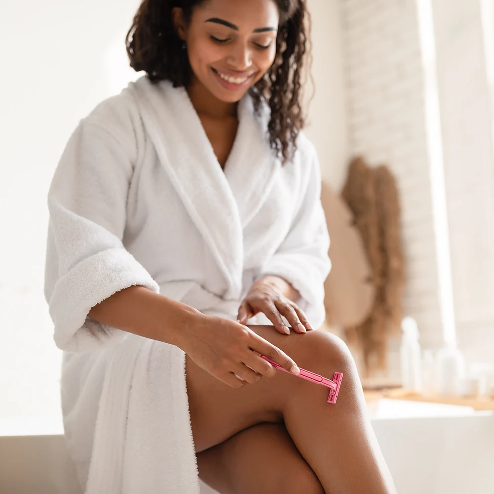 woman preparing for laser hair reduction and shaving her legs