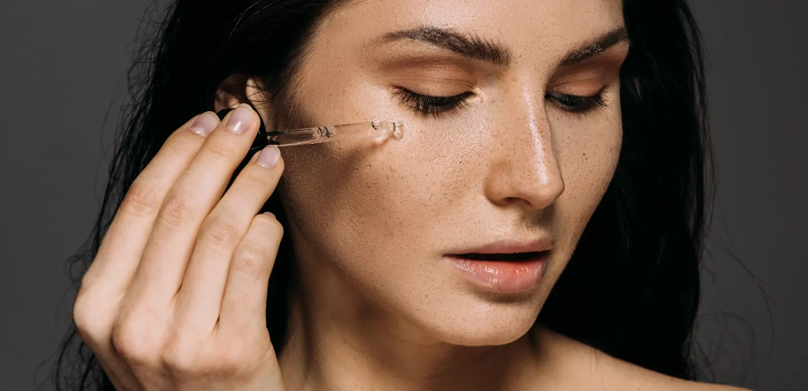 woman applying serum to skin