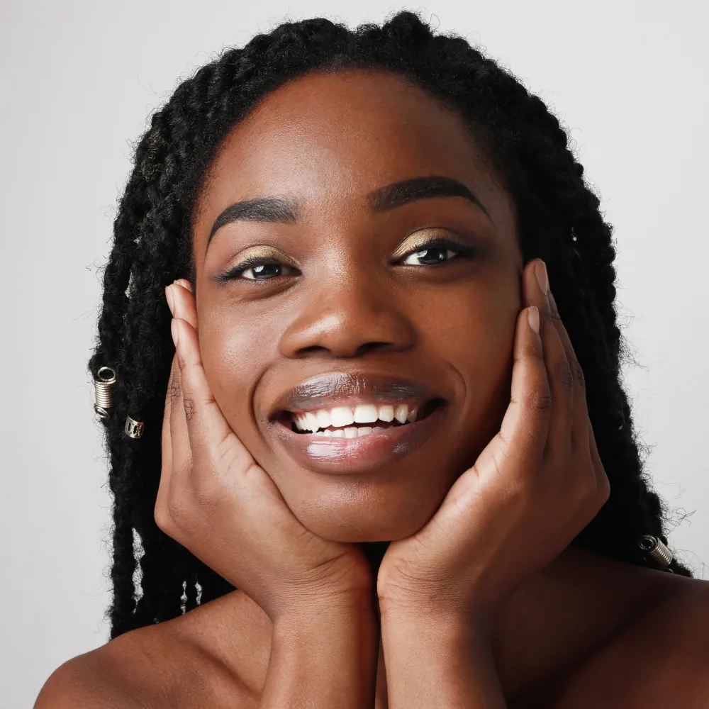 smiling woman touching face with beautiful clean skin