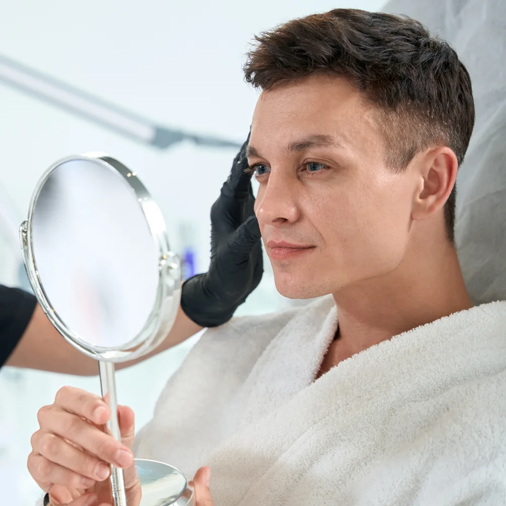 man looking in mirror during botox consultation
