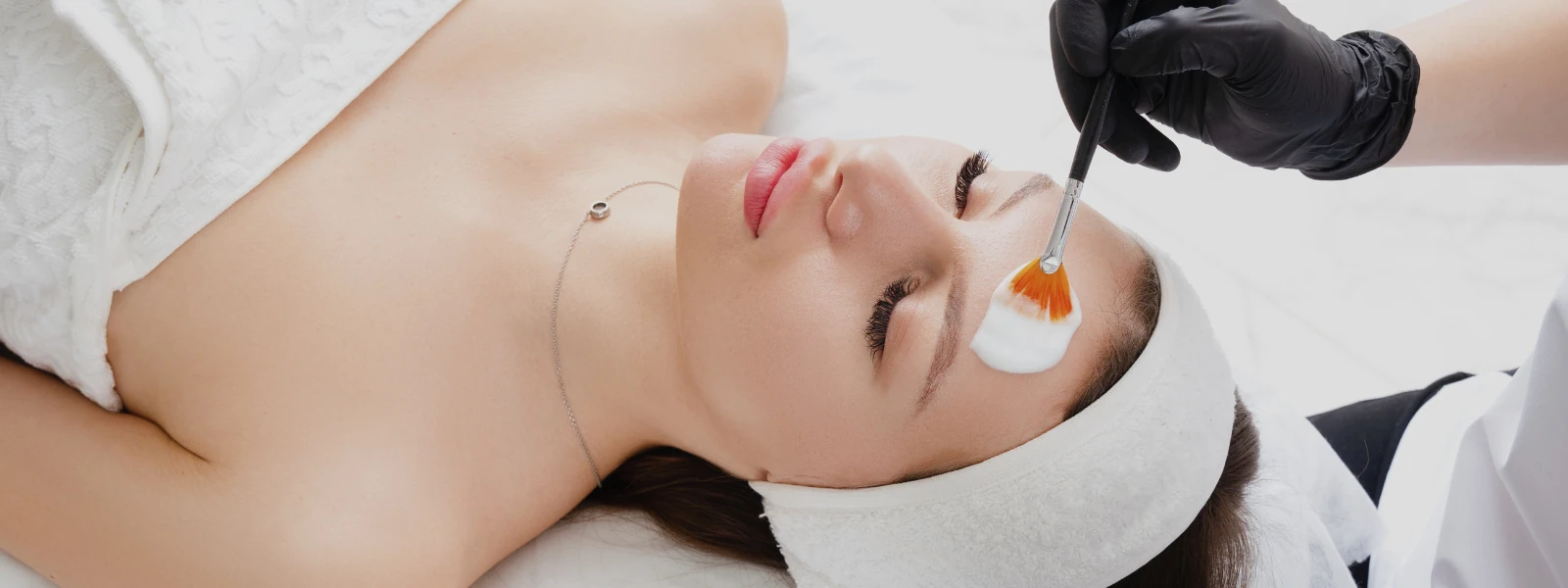 applying chemical peel treatment to woman's face