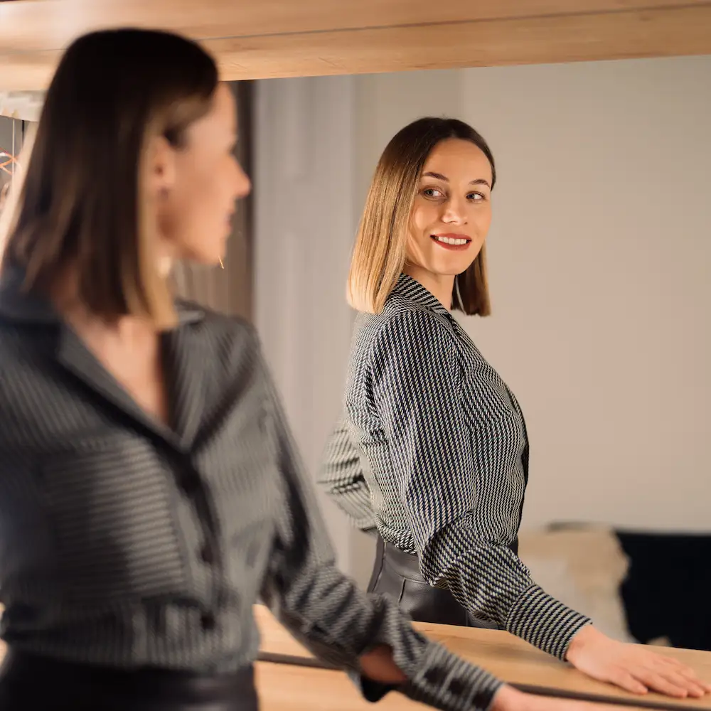 woman looking in the mirror with confidence