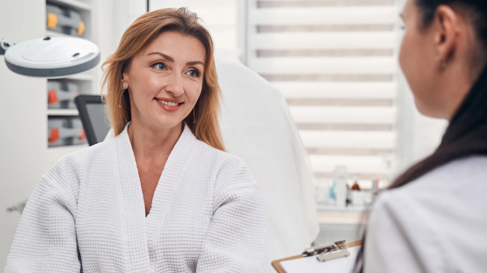 smiling woman talking with provider at cosmetic appointment