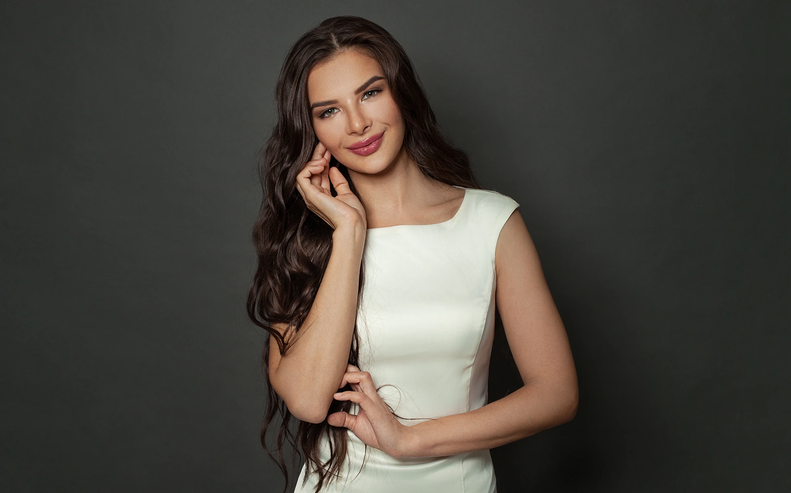 beautiful bride in white elegant dress touching face