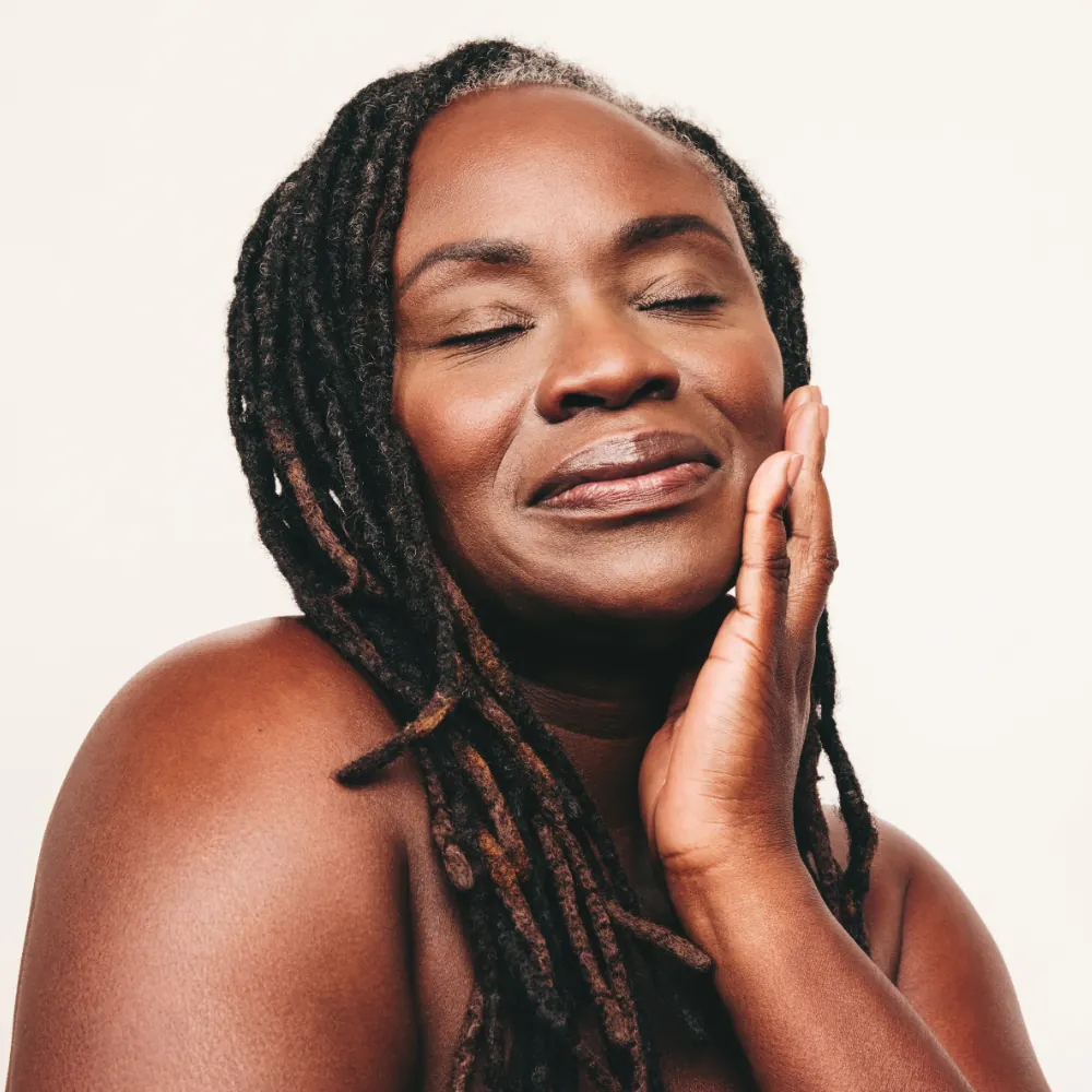 middle-aged woman touching smooth skin on face
